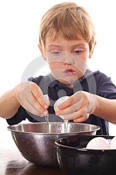 Little boy cracking an egg