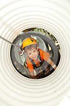 Little boy crawling in adventure park