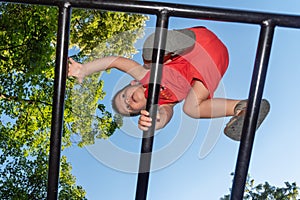 The little boy crosses high obstacles on the children`s playground