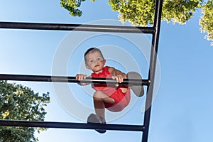 The little boy crosses high obstacles on the children`s playground