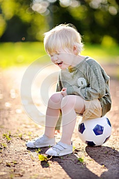 Little boy crying after fall during soccer/football game on summer day