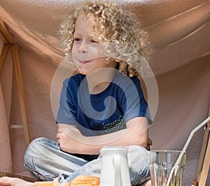 Little boy with curly blond hair, outside