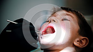 A little boy with damaged baby teeth having a treatment in modern dentistry