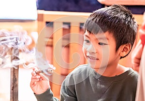 Little boy dangerously playing with burning wood in a wooden house for children danger playing with fire concept photo