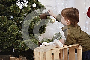 Little boy decorating Christmas tree