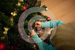 Little boy decorating Christmas tree