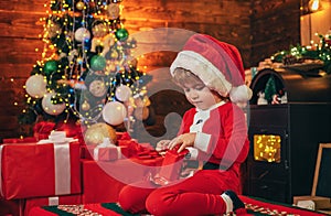 Little boy decorating xmas tree and opening gifts. New Year. Christmas time. Elf child. Winter shopping sale. New Year