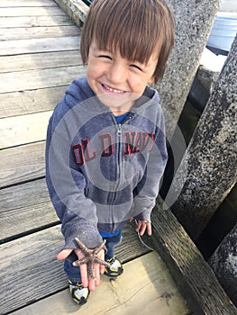 Little boy discovering starfish Deep Bay, BC