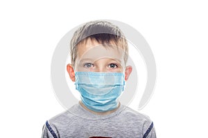 Little boy in a disposable mask on a light background. Kid is wearing the mask for protect them self from virus and air pollution