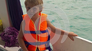 Little boy on a diving boat feel nervous before his first snorkeling in an open sea