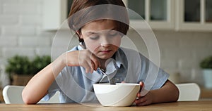 Little boy does not want to eat cornflakes with milk