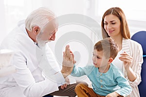 Little boy doing high five with doctor after checkup