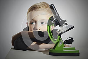 Little boy don't wont to study.sad child.Schoolboy working with a microscope.Smart boy.Education