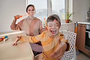 Little boy with Down syndrome joking and playing with his mother