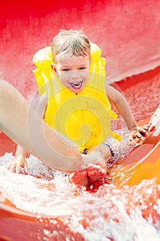 Little boy down with a water slide