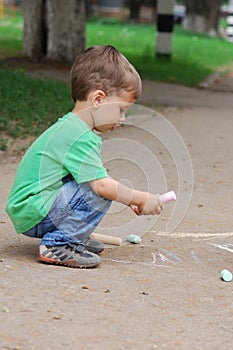 Little boy drawing with chalk