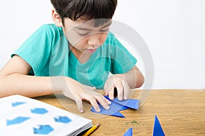 Little boy drawing on paper art origami