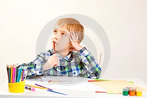 Little boy drawing picture in art class. Kid thinking about new creative idea. Cute preschool child drawing at home. Education,