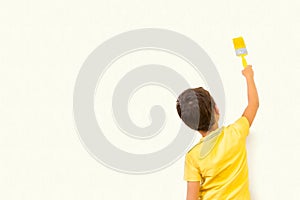 Little boy drawing something on wall background