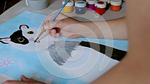 Little boy drawing on white paper sitting at a table at home