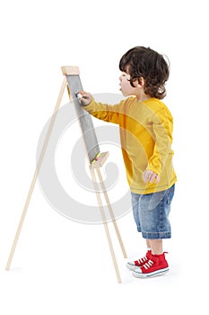 Little boy draws with chalk on chalkboard isolated photo