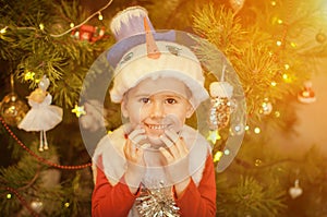 Little boy dressed in a snowman costume having fun near a christmas tree