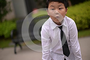 little boy dressed in a white shirt and tie