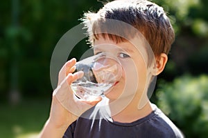 Little boy drink water in nature