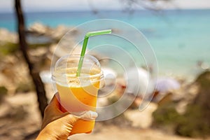 Little boy, drinking cocktail, orange juice on the beack in hammock, enjoying summer Chalkidiki, Greece