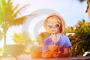 Little boy drinking coconut cocktail on the beach