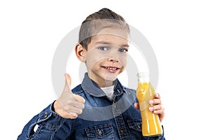 Little boy is drinking fresh orange juice on white background