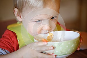 Little boy drinking independently from a bowl