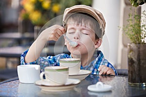 Little boy drinking milkshake in cafe