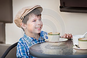 Little boy drinking milkshake in cafe