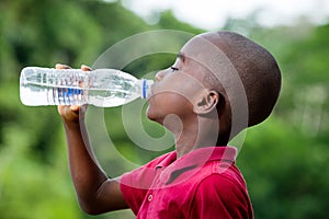 Little boy drinking mineral water outdoors