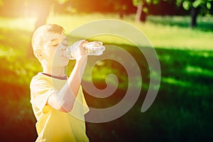 Little boy drinking water from the plastic bottle