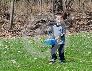 Little boy in a Easter egg hunt outdoors