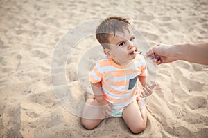Little boy eat icecream from mothers hand;