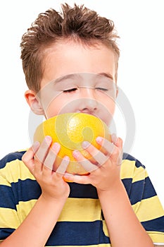 Little boy eatich grapefruit