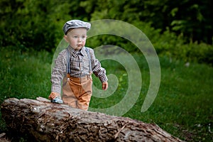 Little boy is eating cake, on background red car, balloons in the park. Birthday of the child