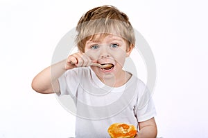 Little boy with eating cheesecake muffin.