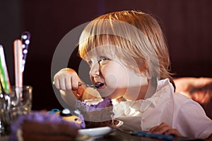 Little boy eating chocolate cake