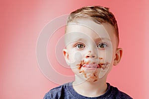 Little boy eating chocolate. Cute happy boy smeared with chocolate around his mouth. Child concept