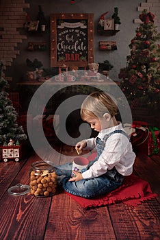 Little boy eating cookies during christmas time.