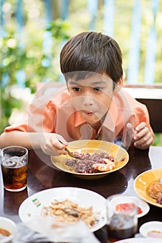 Little boy eating for food meal in the restuarant