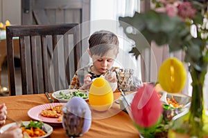 Little boy eating an ice cream at Easter dinner tabe at home