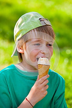 Little boy eating ice cream in the park outdoors