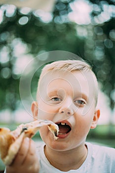 Little Boy Eating Pizza In Cafe In Summer Day