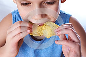 Little boy eating potato chips