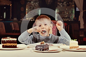 Little boy eating a slice of cake with gusto